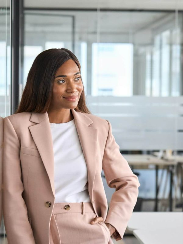Confident young business woman standing in office looking away portrait .jpg