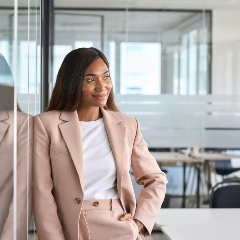 Confident young business woman standing in office looking away portrait .jpg